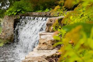A beautiful waterfall flowing in pond at the Koknese park on an summer cloudy day in Latvia. photo