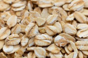 Close-up macro shot of raw oat flakes in shallow depth of field. Side view. photo