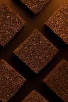 Golden Cubes of flexible foam sponges are laid out in a pattern. Macro close-up in soft focus. Abstract cubic background photo
