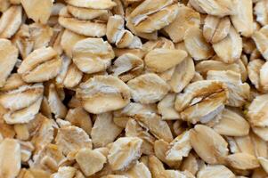 Close-up macro shot of raw oat flakes in shallow depth of field. Top view. photo