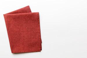 top view with red empty kitchen napkin isolated on table background. Folded cloth mockup with copy space, style photo