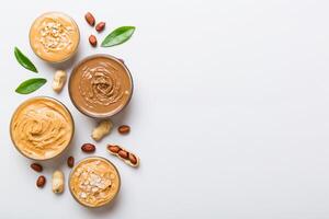 Glass jar with peanut butter on table background, top view space for text and close up photo