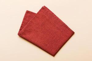 top view with red empty kitchen napkin isolated on table background. Folded cloth for mockup photo