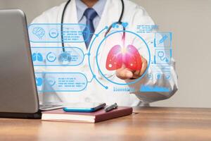Doctor in a uniform read a report about a lung examination on a virtual screen while sitting at a table in a hospital photo