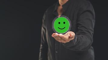 Positive feedback concept. Happy mood icon in hand while standing on a black background photo