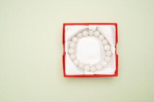Top view fo jade bangle or bracelet in a red box on a green background. photo