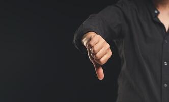 Negative feedback concept. Close-up of a hand showing a thumbs down for dissatisfaction with service photo