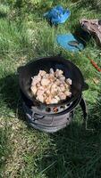 Pilaf with meat the process of preparing the culinary dish pilaf in a cast iron frying pan over a wood fire outdoors photo