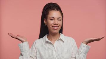 Smiling young woman weighing options with hands on pink video