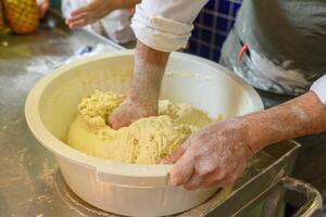 hand of a person kneading water, salt and flour for bread dough preparation photo