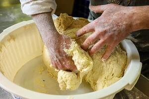 hands of a baker kneading bread. baker's hands developing dough texture photo