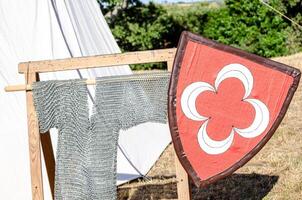 close view of a medieval shield and hanging chainmail shirt at a historical recreation party event photo