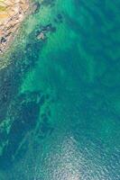 aerial top down drone view, coastal feature in a rocky shore with turquoise water photo