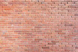 Large piece of weathered red brick wall with a rough appearance creates a textured backdrop for architectural visualizations, old building wall, photo