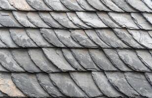 Traditional slate roof tiles are overlapping, creating a textured and patterned surface, providing durable and weather resistant protection for the building photo