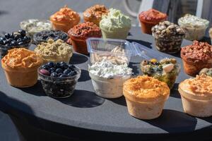 On the table are bowls filled with colorful sauces, olives and other Mediterranean delicacies, offering a variety of flavors and textures to choose from. photo