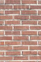 vertical shot of weathered red brick surface with textured wall pattern with mortar lines, ideal element for layout, design and smartphone wallpaper, sunny day photo