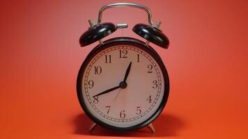 An alarm clock on an red background time lapse. video