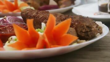 Delicious grilled meat with fresh vegetable garnish served on a white plate in a cozy dining setting video