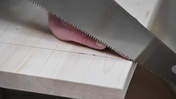 Close-up of Hand Carefully Sawing Wood on Workshop Table with Precision and Safety video