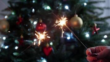 Sparkling Holiday Celebration with Handheld Sparklers Near Festive Christmas Tree Lights and Decorations video