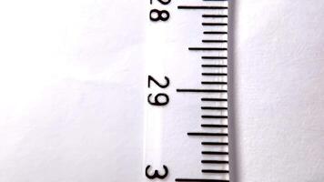 Detailed close-up of a measuring tape with centimeter marks on a white background. video