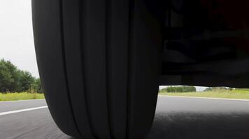 Dynamic Low Angle POV Shot of a Car Tire Rolling on Open Road in Daylight Driving Scene video