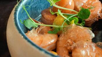 Close-up of Fresh Cooked Shrimps with Green Garnish in a Modern Ceramic Bowl on Dark Surface video