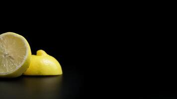 Close-up of Fresh Juicy Lemon Halves on a Black Matte Surface with Dramatic Lighting video