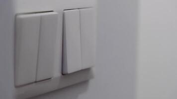 Close-up of a hand pressing a wall switch to turn on a light, emphasizing daily routines and home electrical control. video