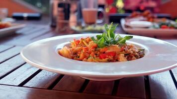 A white plate with food on it sitting on a wooden table video