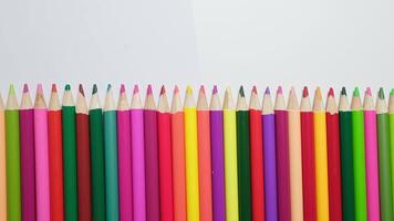 Vibrant and colorful assortment of sharpened colored pencils neatly arranged on white background in creative workspace video