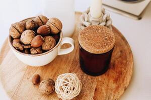 Decorative bowl of nuts and jar with cork lid on wooden surface in cozy setting photo