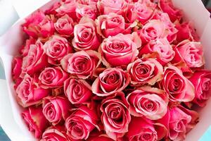 Beautiful bouquet of pink roses arranged elegantly in a decorative white wrapper photo