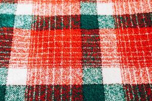 Colorful plaid fabric with red and green checkered pattern on a soft surface photo
