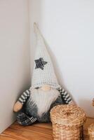 Decorative gnome sitting on wooden shelf surrounded by woven baskets and soft lighting photo