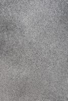 Gray textured surface showing natural variations in color and pattern during daylight hours photo