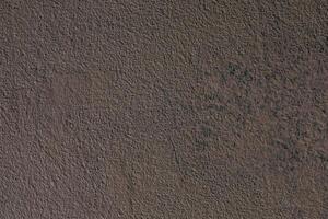 Surface texture displaying earthy tones and subtle variations in color and pattern on a wall photo