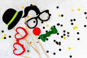 Fun and colorful party props arranged on a sparkling silver background for celebrations photo