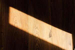 Light casts shadow on wooden floor creating a serene atmosphere indoors photo