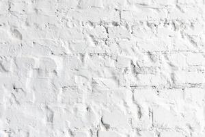 Textured white brick wall with subtle details and shadows in an indoor setting photo