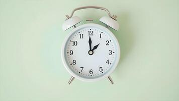 Daylight saving time. White alarm clock on light green background, top view. Highlighted area and arrow showing time change by one hour forward photo