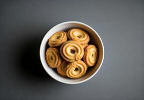 Bowl with Danish butter cookies on grey table, top view photo