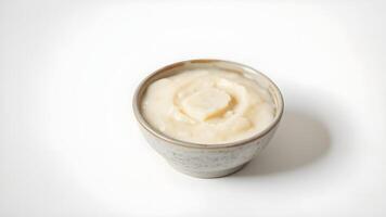 Close-up of a bowl of creamy mashed potatoes on a white surface photo