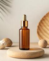 A bottle of essential oil is on a wooden plate with a stone and a palm leaf photo