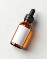A bottle of essential oil on a white surface photo