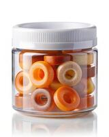 A jar filled with orange and white donuts photo