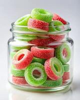 A jar filled with green and red gummy rings photo