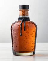 A bottle of maple syrup with a black lid photo