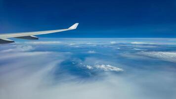 The view from the airplane window to the clouds. Airplane wing above thick blue and white clouds. Wonderful sky photo